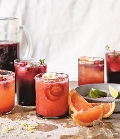 three glasses filled with blood orange juice and garnished with limes on the side