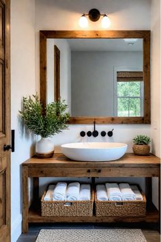 a bathroom with a sink, mirror and baskets on the counter in front of it