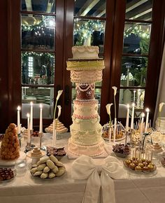 a tall cake sitting on top of a table covered in lots of food