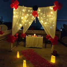 an outdoor dining area decorated with red and white balloons, lights and sheer drapes