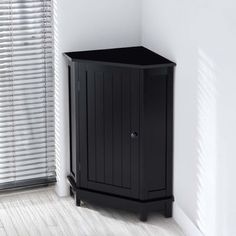 a small black cabinet sitting next to a window