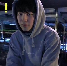 a young man in a hoodie is staring at the camera