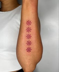 a woman with a tattoo on her arm that has flowers in the middle of it