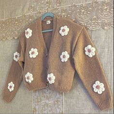 a brown sweater with white flowers on it