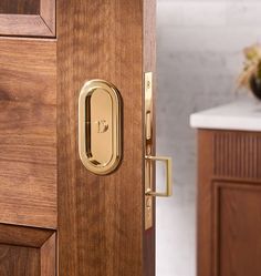 a close up of a door handle on a wooden cabinet with a marble counter top