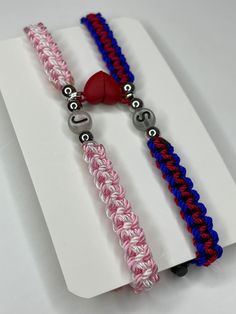 two bracelets with red, white and blue braided ends on a piece of paper