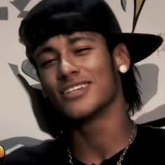 a young man wearing a black hat and smiling