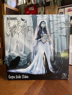 the corpse bride statue is on top of a wooden table