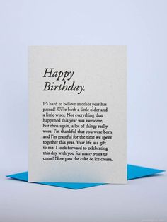 a card with the words happy birthday written in black and white on it, sitting on top of a blue envelope