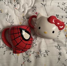 hello kitty and spiderman mugs on a bed