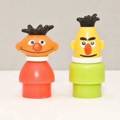 two plastic toys with faces on them sitting next to each other