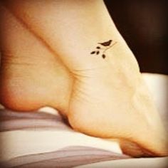 a person with a small bird tattoo on their foot