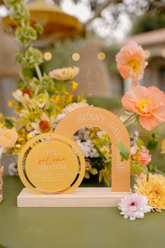 a table topped with flowers and candles on top of a green table covered in yellow plates