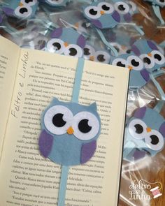 an open book sitting on top of a wooden table next to some paper owl decorations