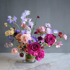 a vase filled with lots of different colored flowers