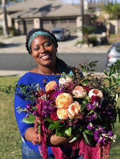 a woman holding a bouquet of flowers in her hands