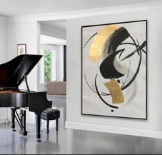 a living room with a grand piano in the center and paintings on the wall behind it