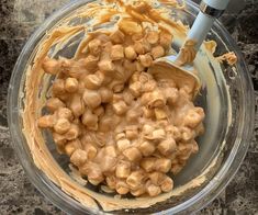 a glass bowl filled with peanut butter on top of a counter