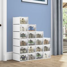 a white shoe rack with shoes on it next to a blue wall in a living room