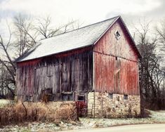 an old red barn in the middle of winter