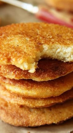 a stack of fried food on top of a table next to a fork and spoon