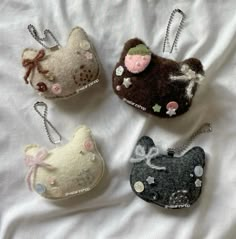 four small purses are sitting on a bed with white sheets and one has an animal head