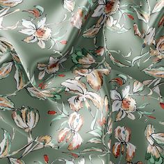 a green floral print fabric with white and orange flowers