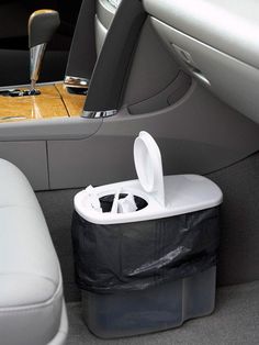 the back seat of a car with two trash cans and a plastic bag in it