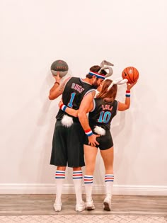 two basketball players are standing next to each other with their hands on their hipss