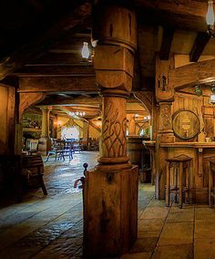 the inside of a restaurant with wooden tables and stools, wood walls and ceiling