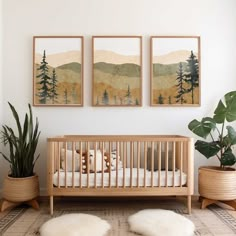 a baby crib with two paintings on the wall