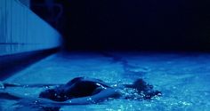 a woman swimming in a pool with blue lights