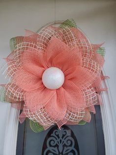 an orange mesh flower is hanging on the front door