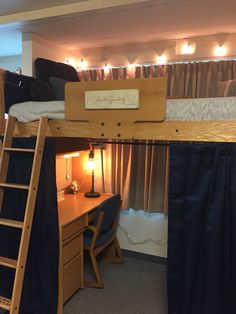 a bunk bed with a desk underneath it and lights on the wall above it, in a bedroom