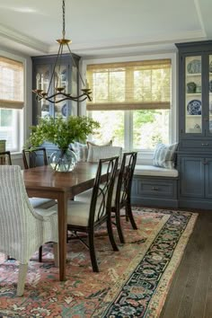 the dining room table is surrounded by chairs and a bench in front of a window