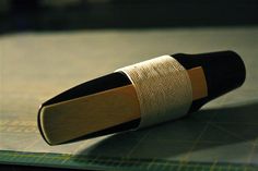 a book with a piece of cloth wrapped around it on top of a cutting board