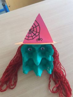 an origami hat with red hair and eyes