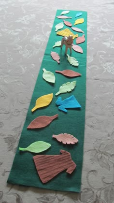 a green table runner with paper leaves and a monkey on it's back side