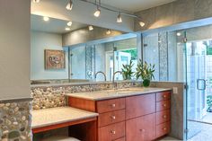 a bathroom with double sinks and large mirrors