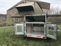 the back end of a truck with an awning on it's roof and door open