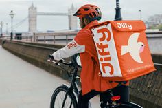 a person riding a bike with a bag on the back