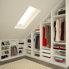 an attic closet with white shelving and lots of clothes