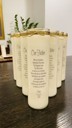 four white candles sitting on top of a wooden table