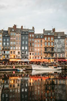 boats are docked in the water near some buildings with windows and balconies on them