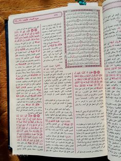 an open book with arabic writing on the pages and in two different languages, one is pink