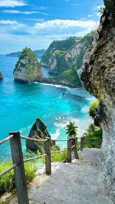 stairs leading down to the beach with blue water