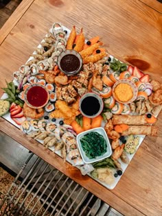 an assortment of appetizers and dipping sauces on a wooden table