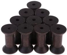 many spools of black thread are arranged in a pyramid on a white background