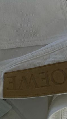 a close up of a white shirt with the name toteme written on it