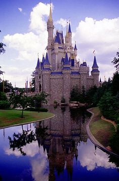 a castle is shown with its reflection in the water and trees on either side of it